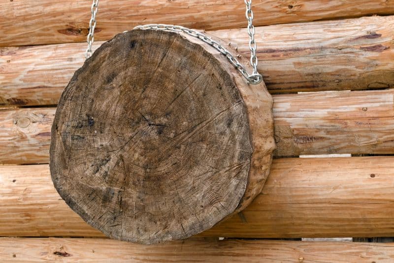 A round wooden knife throwing target hanging on a wooden wall